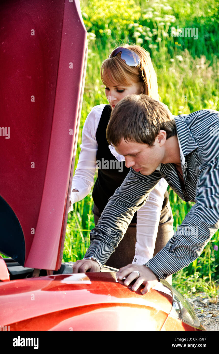 Man and woman are looking at the car engine Stock Photo - Alamy