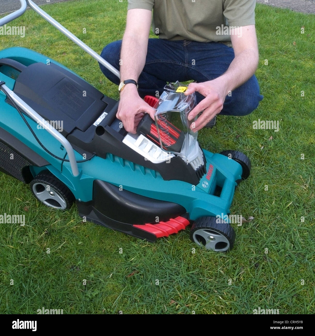 Caucasian Man Changing a Rechargeable Battery on a Bosch Rechargeable  Electric Lawnmower MODEL RELEASED Stock Photo - Alamy