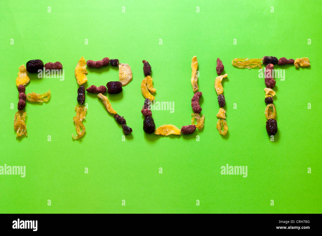 Various dried and sugarcoated fruits spelling the word "fruit" in studio setting Stock Photo