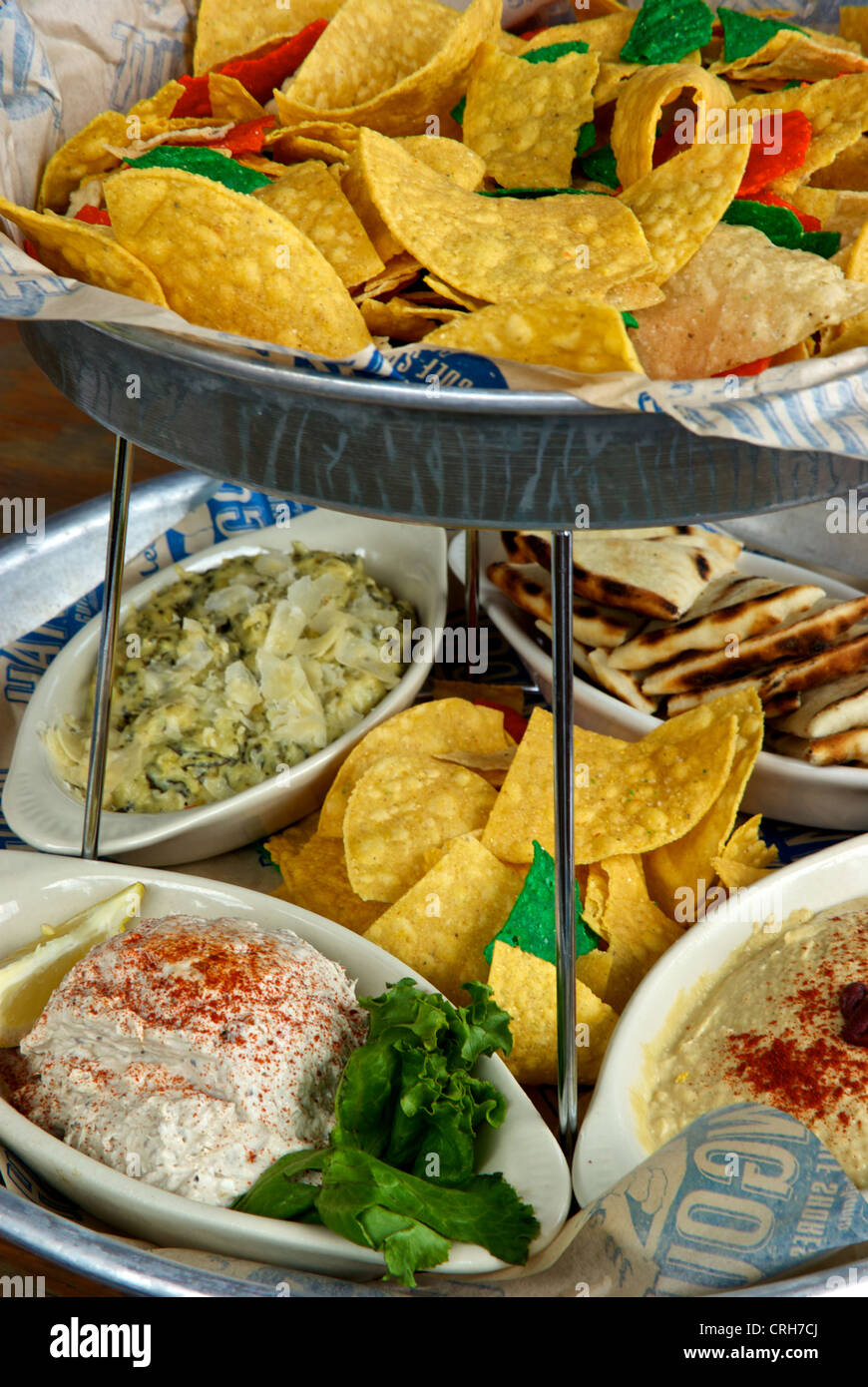 Two tier appetizer tray corn chips pita bread wedges three dips The