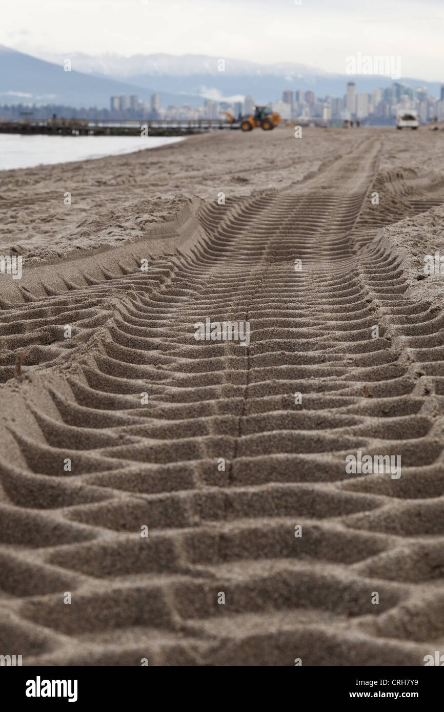 Low perspective of large tire tracks left from a tractor doing maintenance work on Jericho beach in Vancouver British Columbia Stock Photo