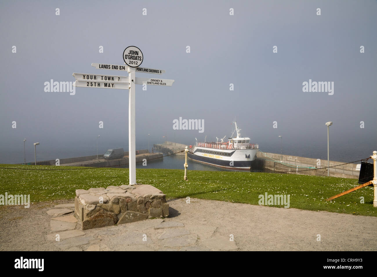 John o' Groats Caithness Scotland May Signpost in front of Pentland Venture passenger ferry on misty day Stock Photo