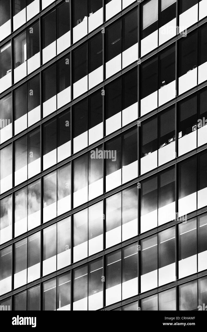 Stormy rain clouds reflected in Office block glass windows. Tottenham Court road London. Monochrome Stock Photo