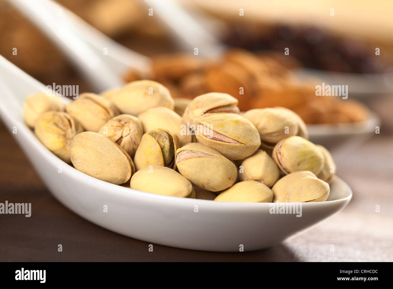 Roasted pistachio nuts with shell (Selective Focus, Focus on the upper right pistachio) Stock Photo