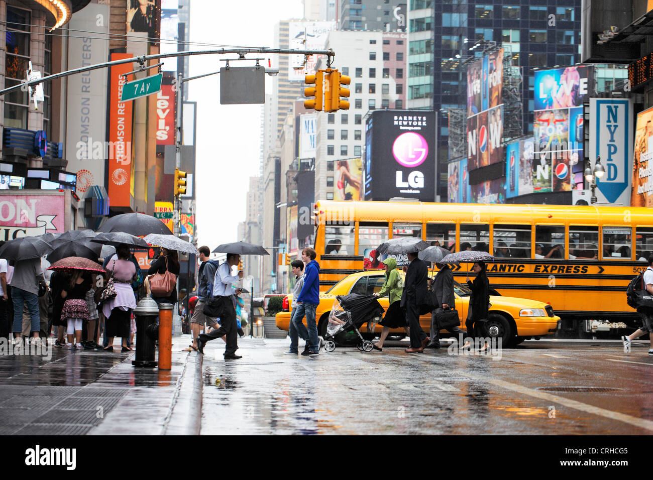 NEW YORK CITY, USA - JUNE 12: People crossing a street in rainy Times Square. June 12, 2012 in New York City, USA Stock Photo