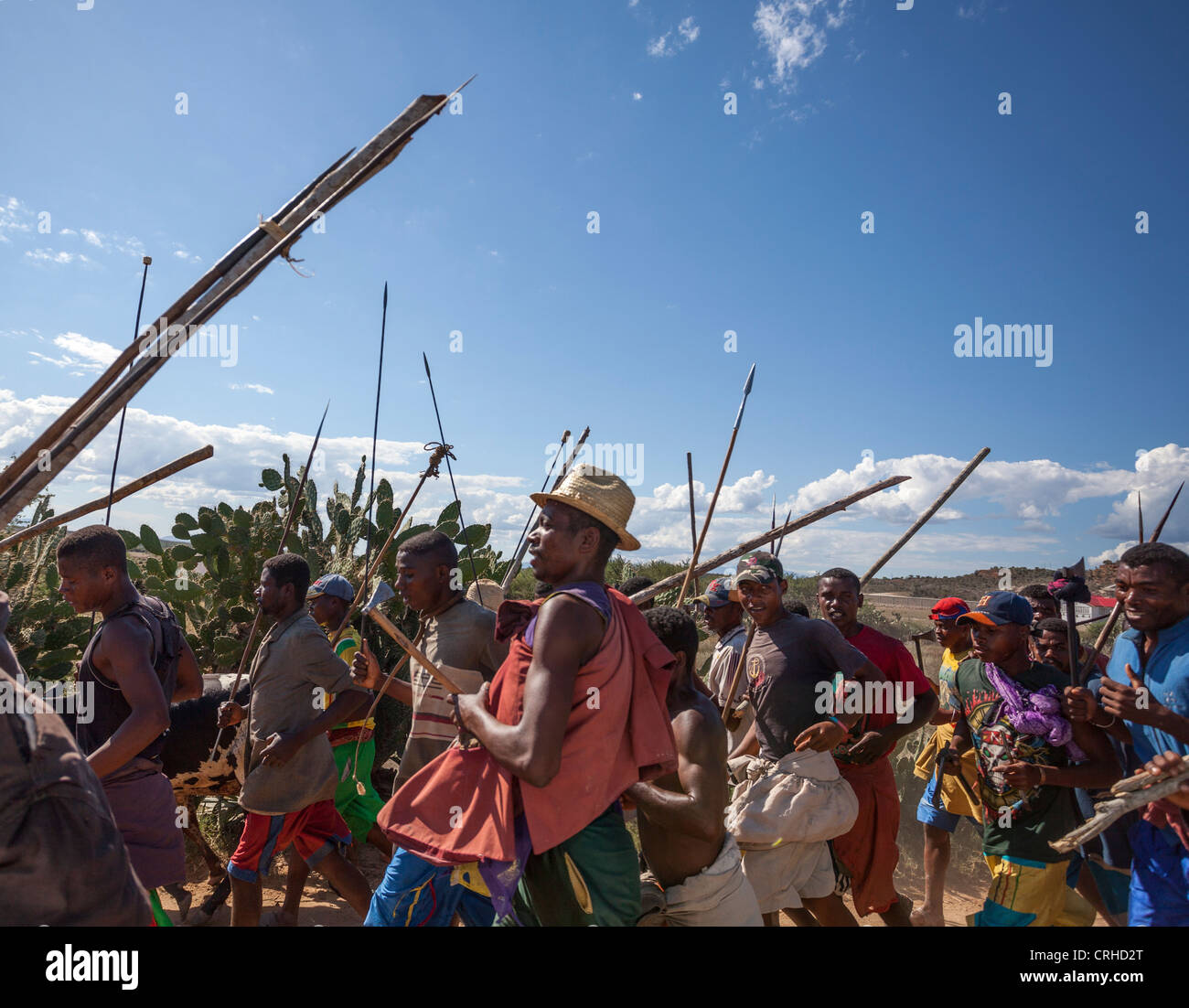 Malagasy tribesmen with spears running to dina in nearby town to settle cattle theft dispute Stock Photo