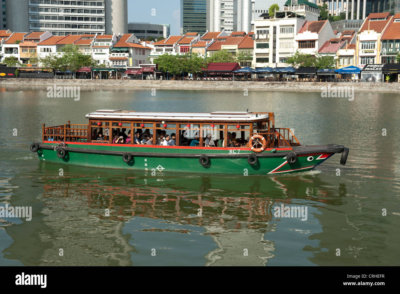 Excursion and ferry boat on Singapore River in front of Boat Quay at daytime in Singapore, Asia Stock Photo