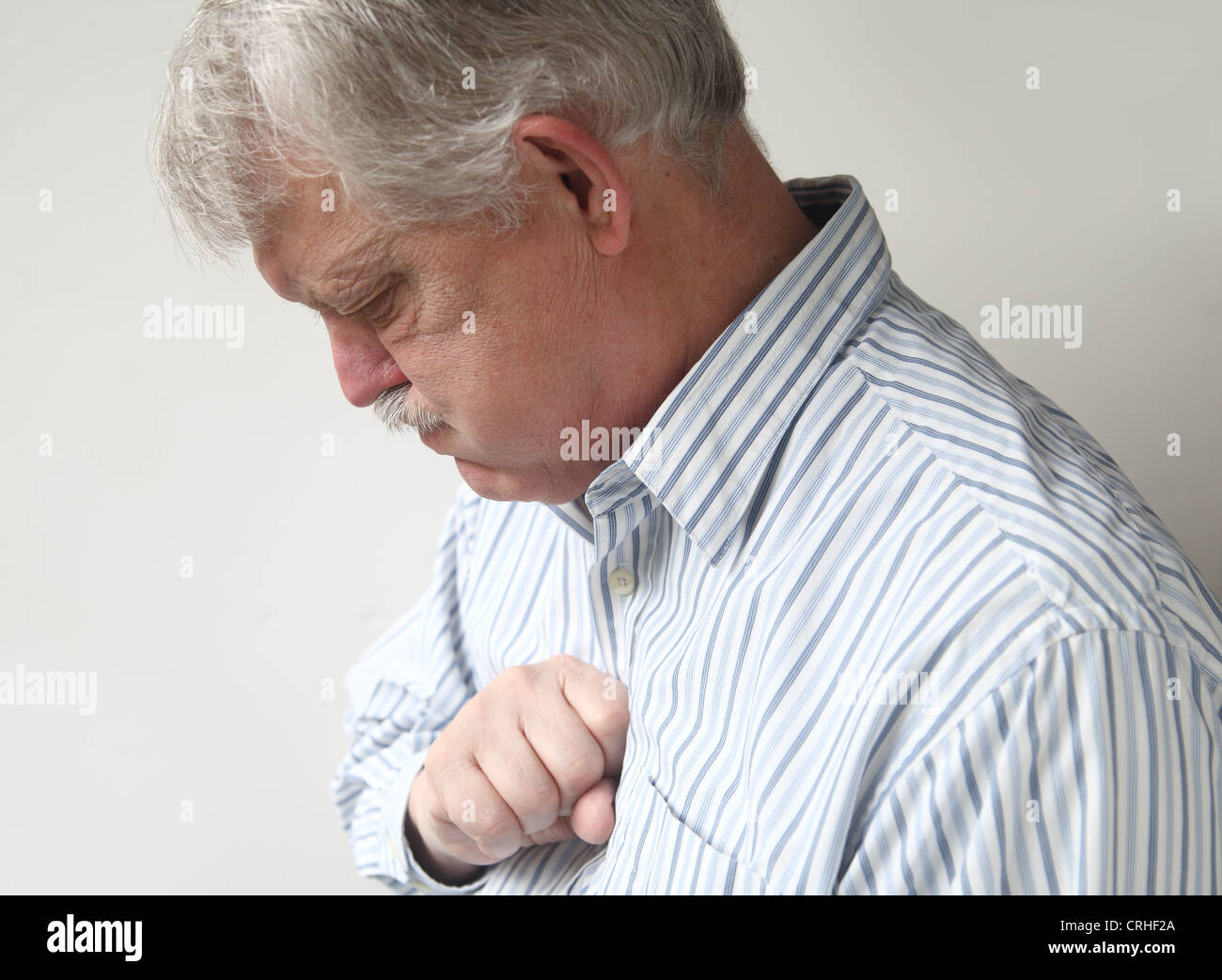 businessman with chest discomfort that could be either heartburn or a heart attack Stock Photo