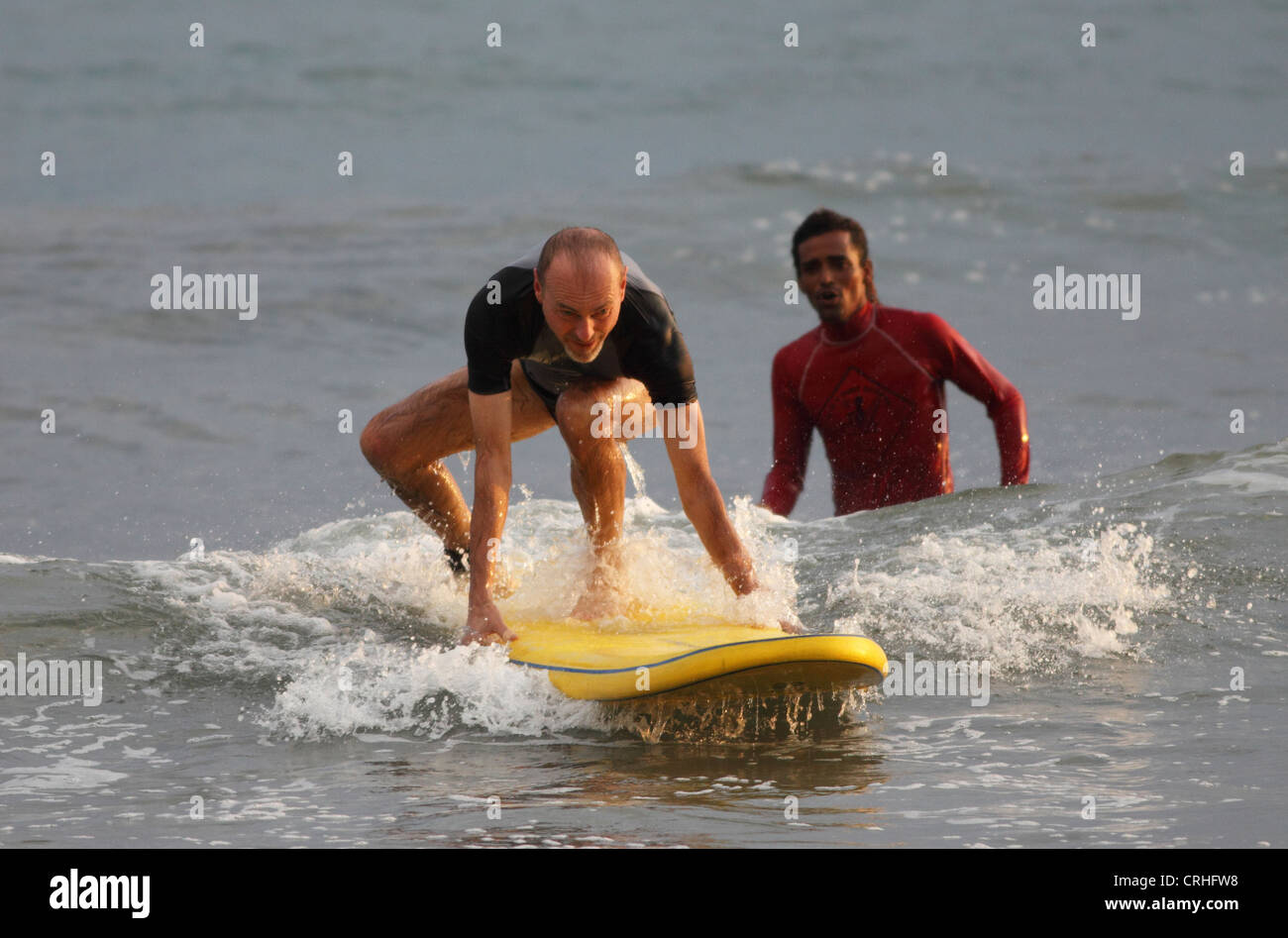 Surfer with surf instructor on Samara Beach, Guanacaste, Costa Rica. Stock Photo