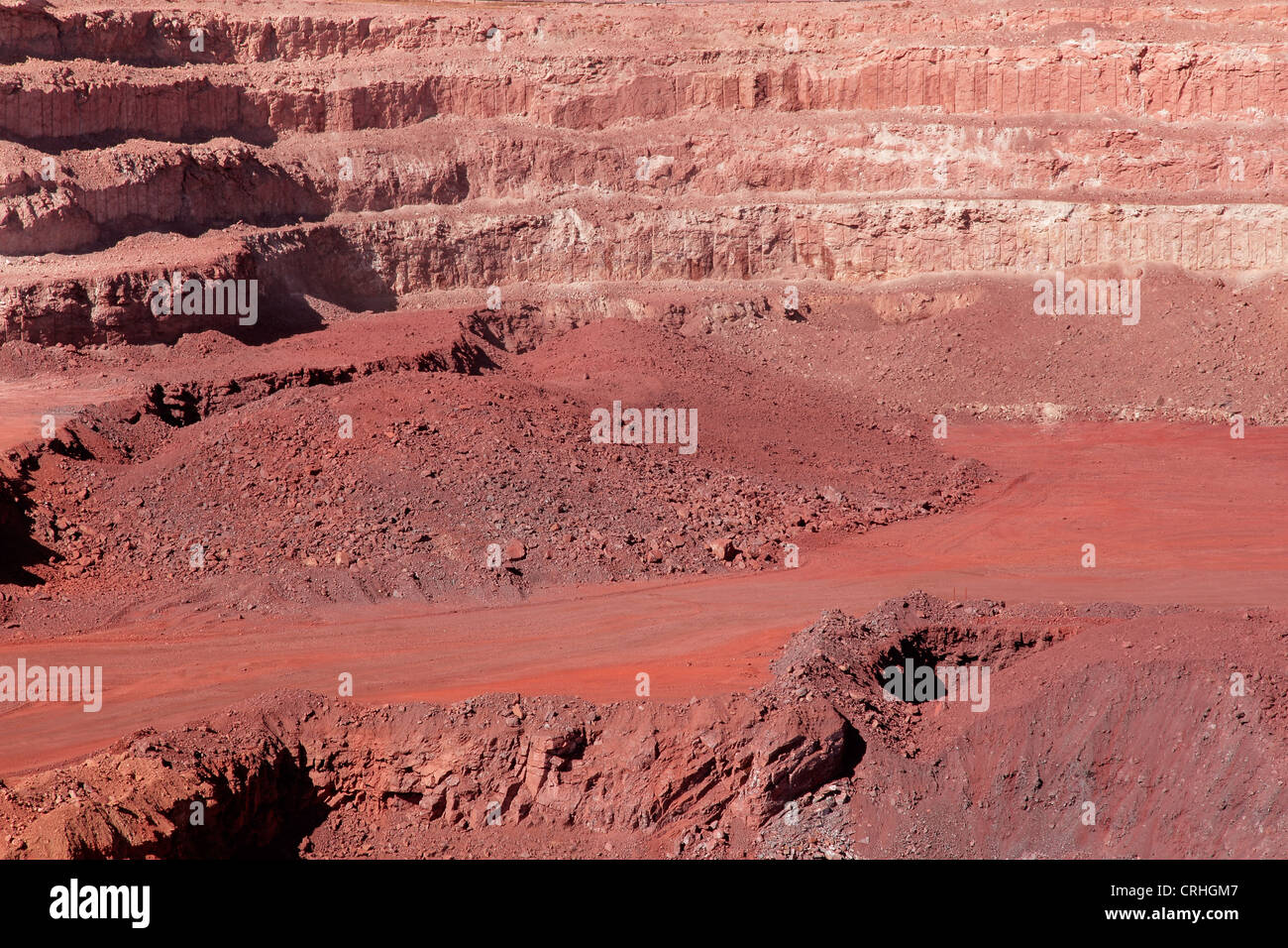 Large, open-pit iron ore mine showing the various layers of soil and iron rich ore Stock Photo