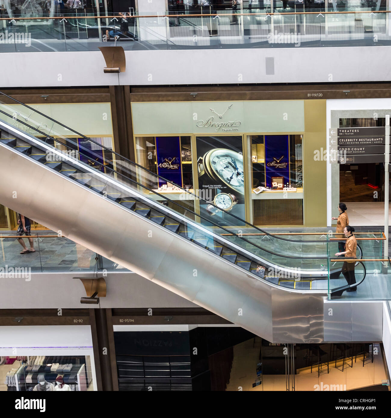 Person about to use an escalator in shopping centre in Marina Bay Sands, Singapore Stock Photo