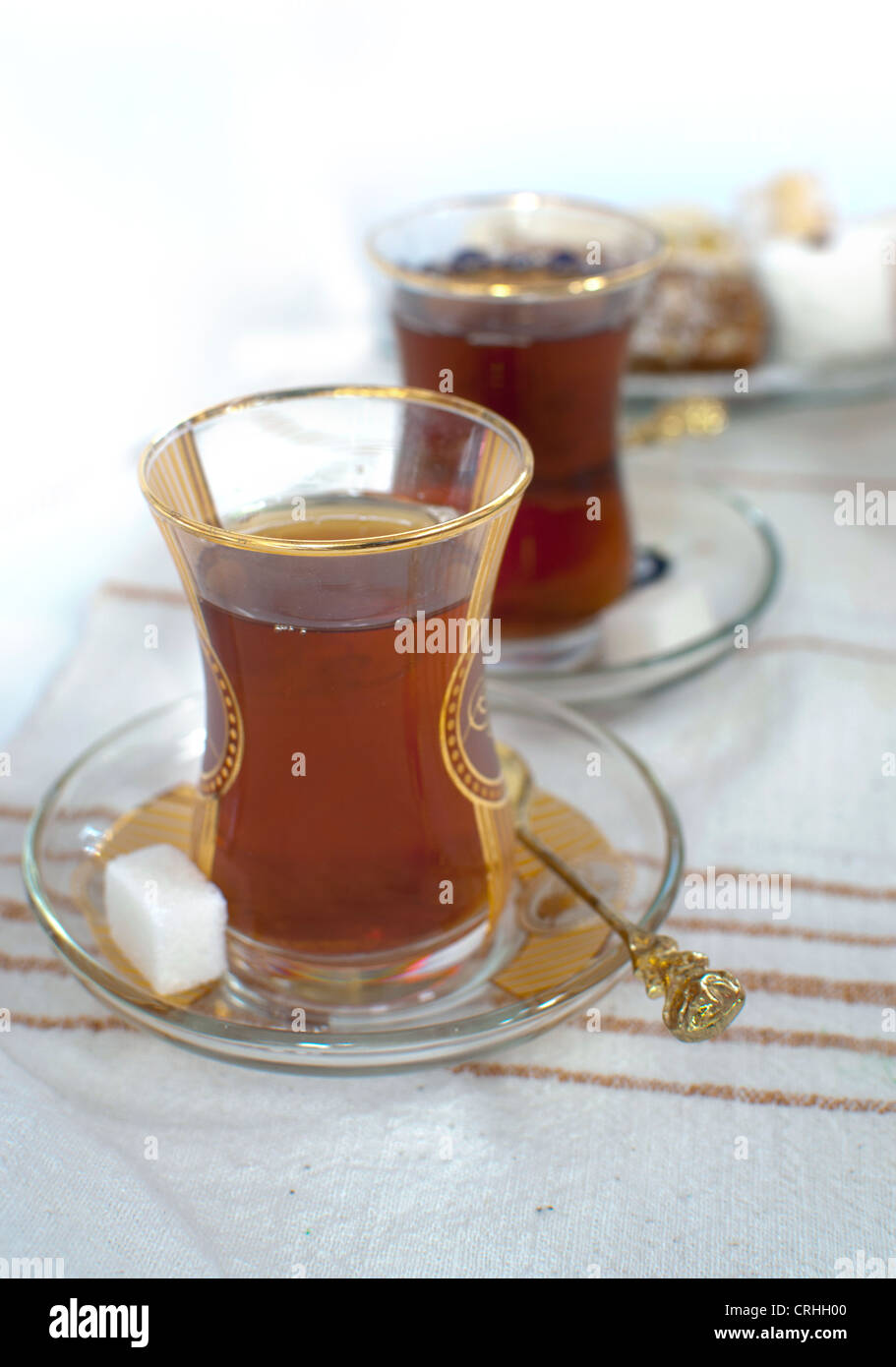 Traditional turkish chai in two glasses, served with sugar cubes Stock