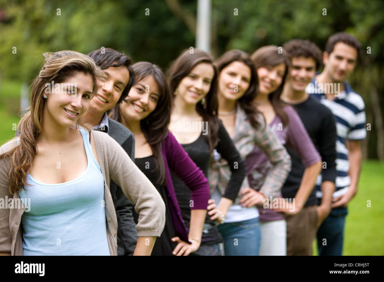 group of students standing one behind another, hands on hips, smiling