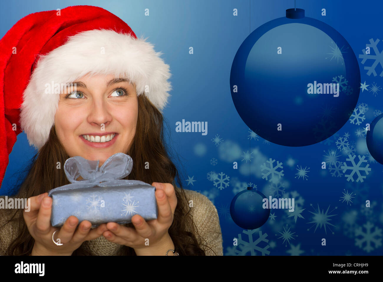Young woman in Santa hat holding Christmas gift, portrait Stock Photo