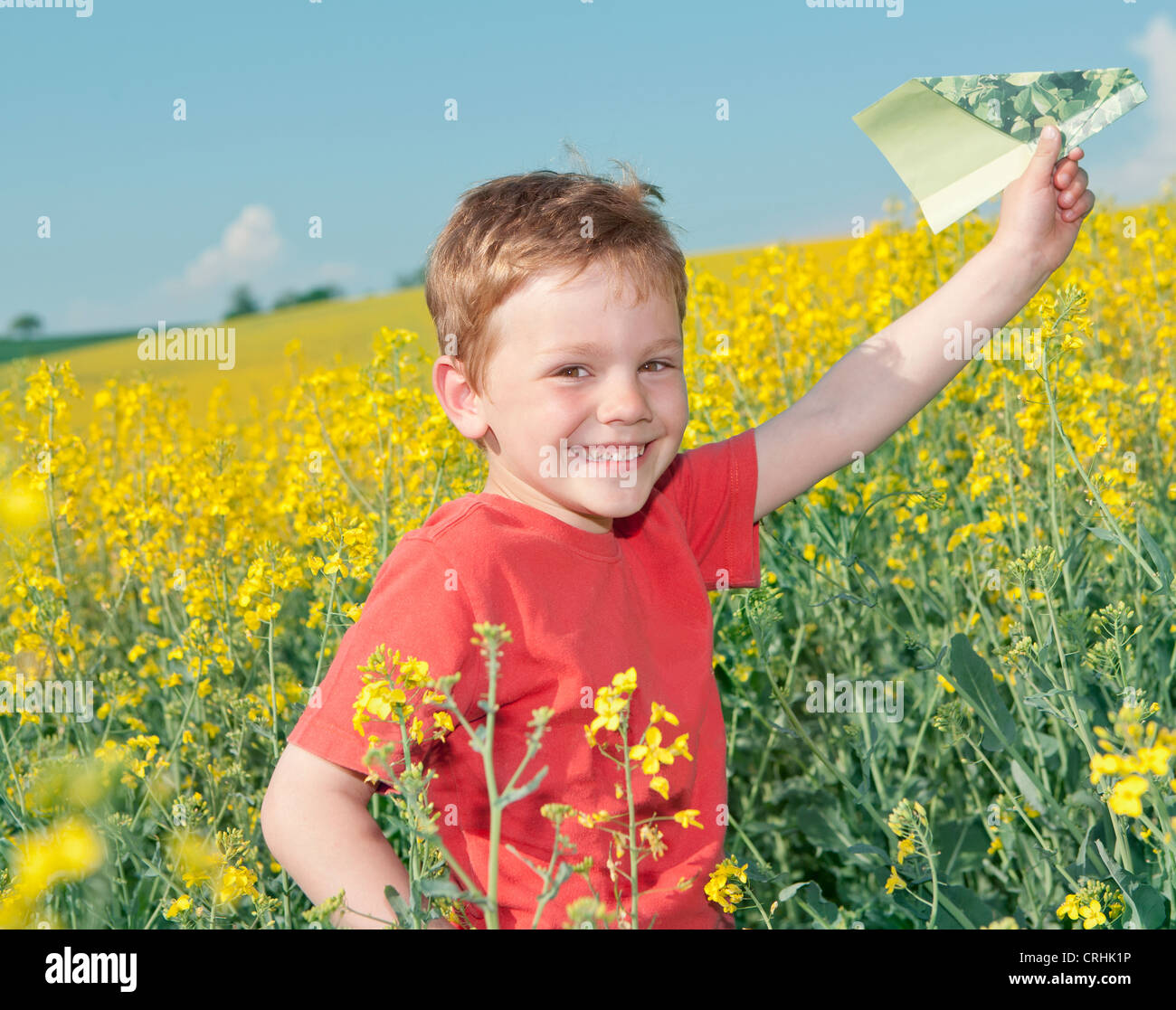 Boy playing with paper airplane in field Stock Photo - Alamy