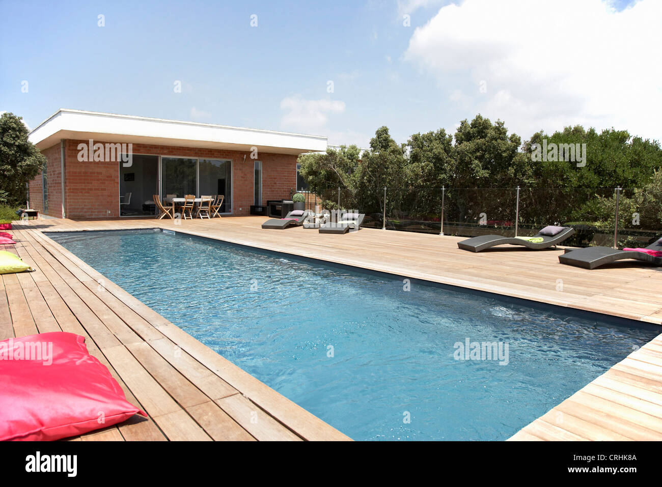 Lawn chairs and pool on modern deck Stock Photo Alamy