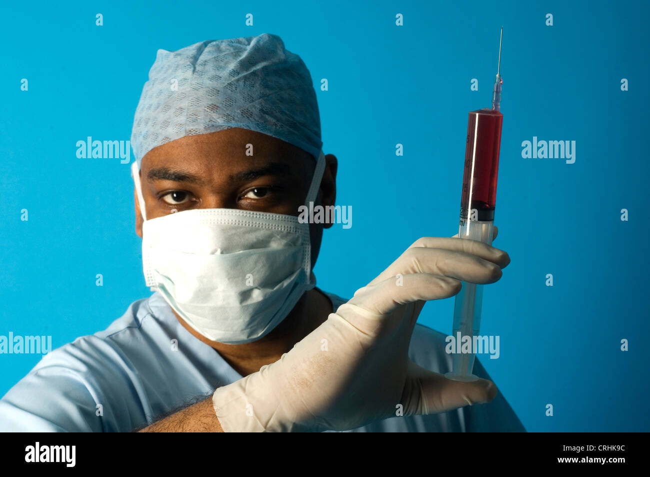 Surgeon holding a syringe. Stock Photo
