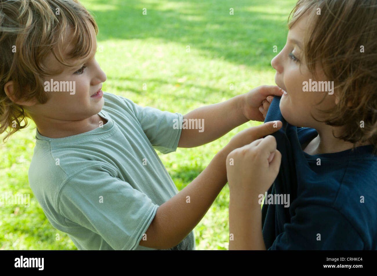 Boys fighting, one gripping the other's shirt Stock Photo