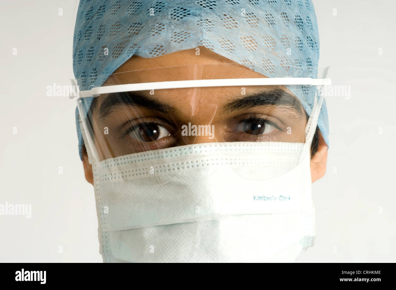 Close-up of the face of a surgeon wearing a surgical visor, hygiene mask, hygiene hat. Stock Photo