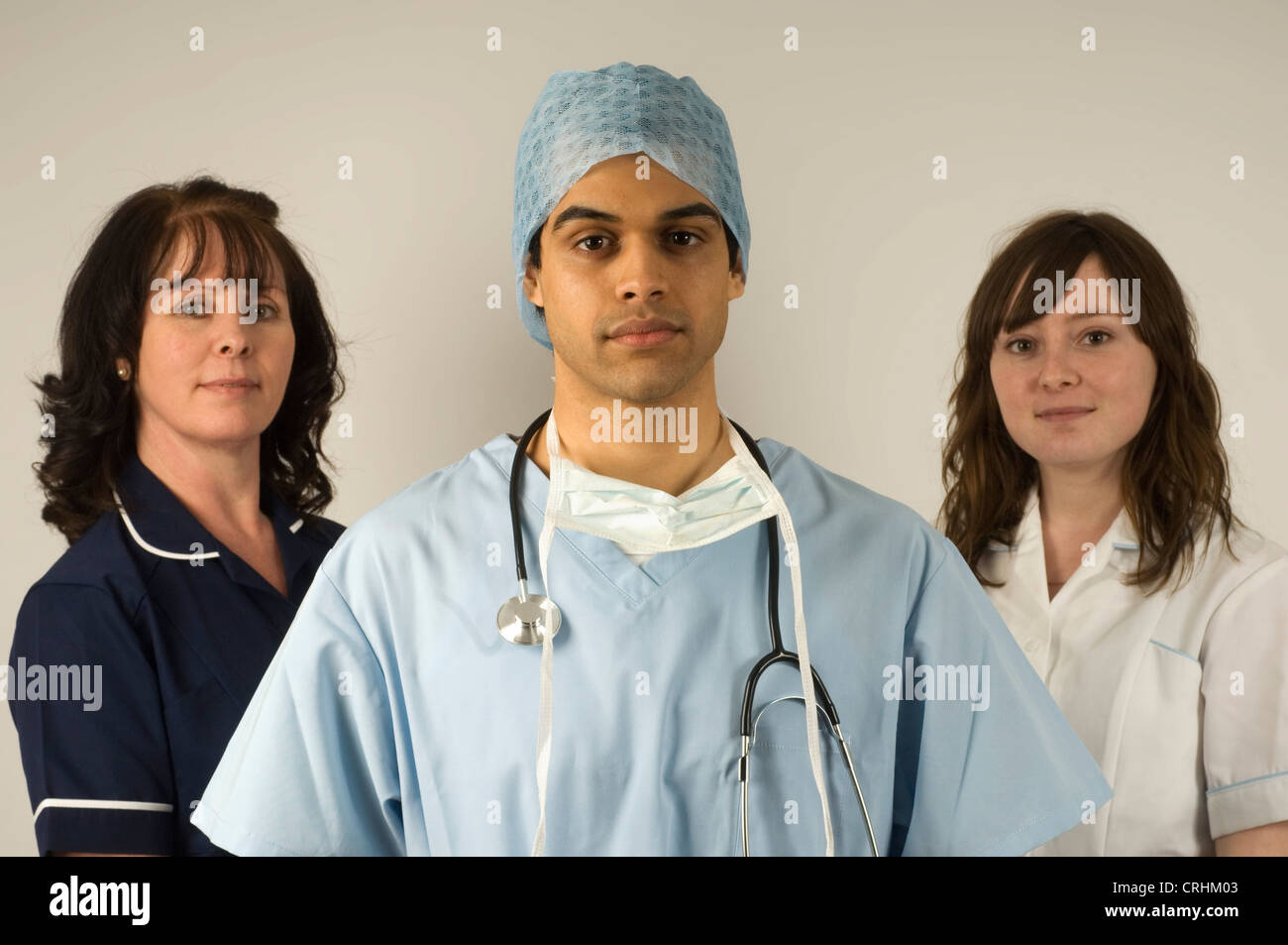 A surgeon stands between two hospital nurses. Stock Photo