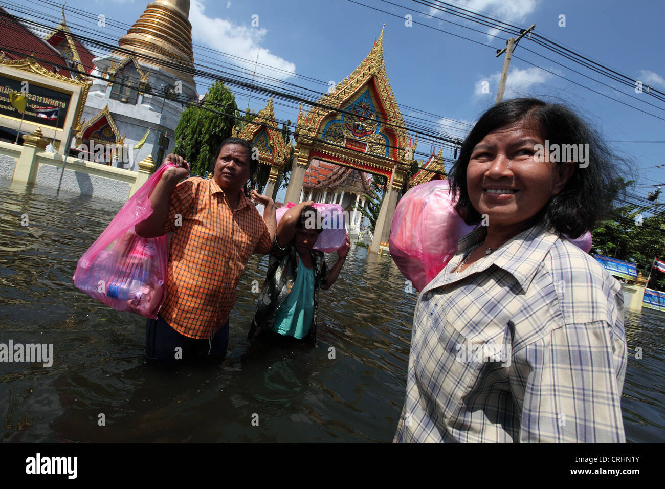 Women carry rations of food and water as floods devastate the Don Muang ...