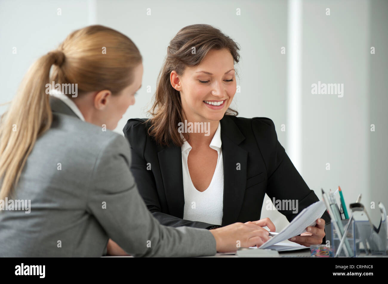 Businesswoman reviewing document with client Stock Photo