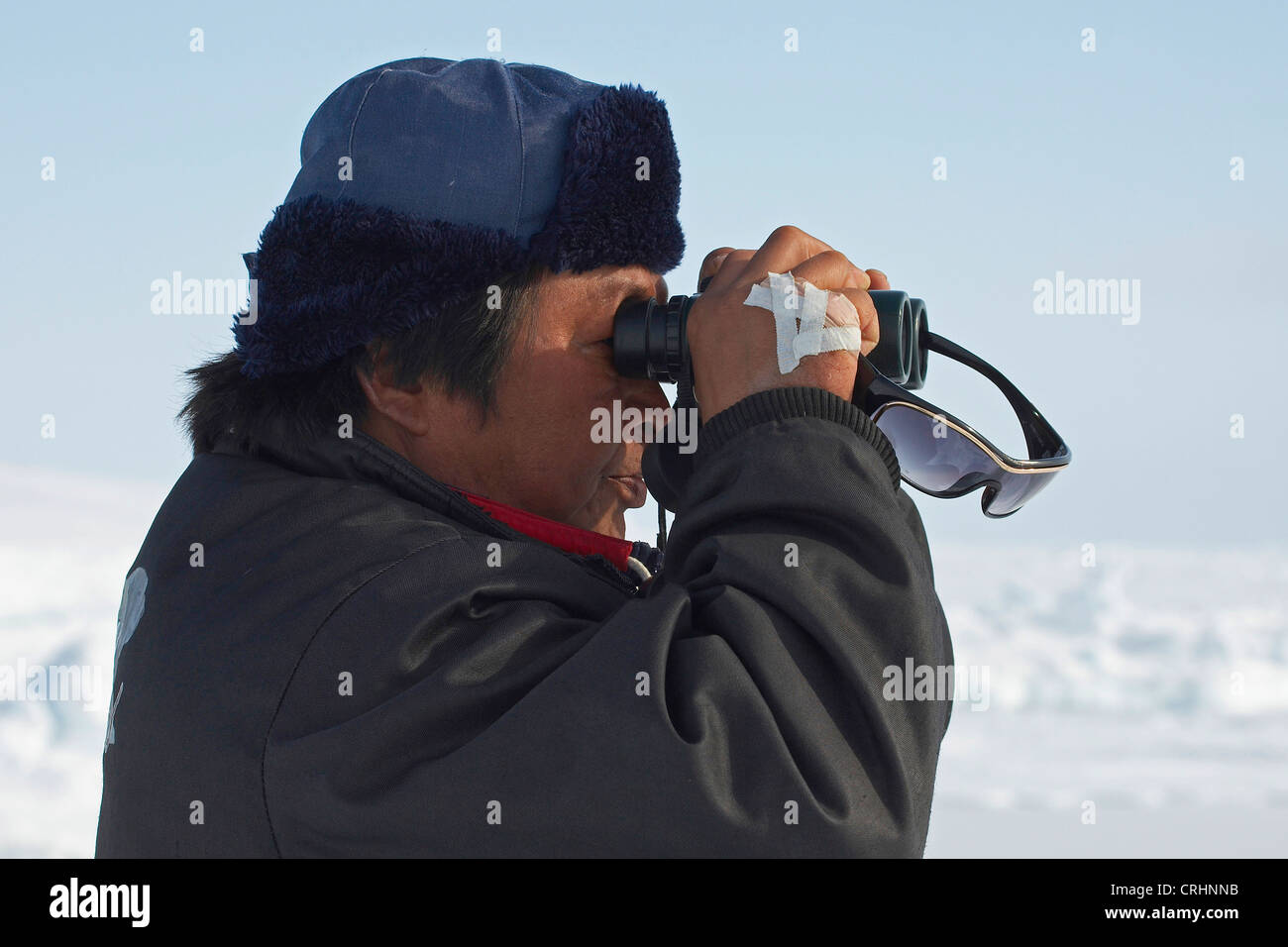 Inuit looking for seals with a binocular, Greenland, Ostgroenland, Tunu, Kalaallit Nunaat, Scoresbysund, Kangertittivag, Kap Tobin, Ittoqqortoormiit Stock Photo