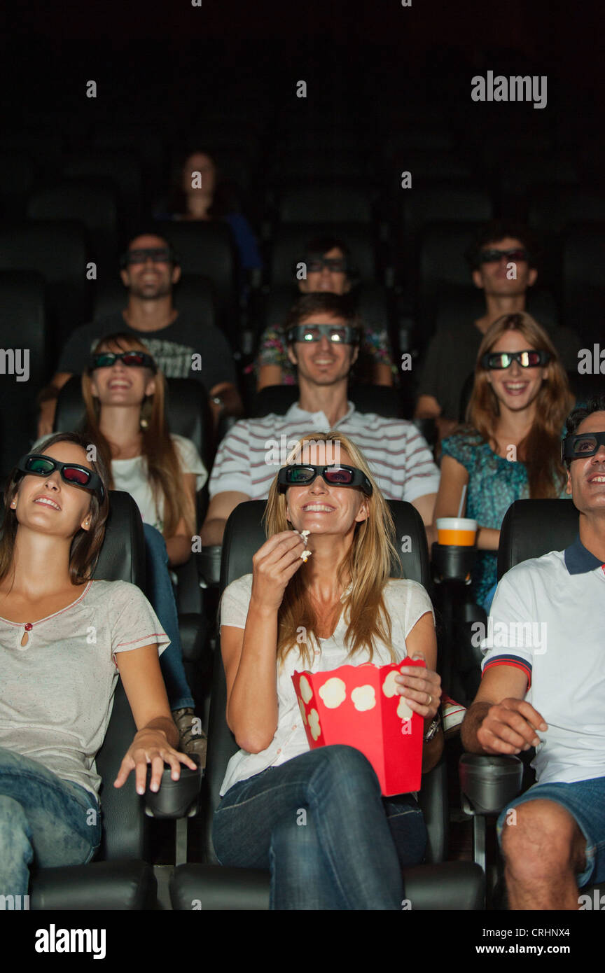 Audience wearing 3-D glasses in movie theater Stock Photo