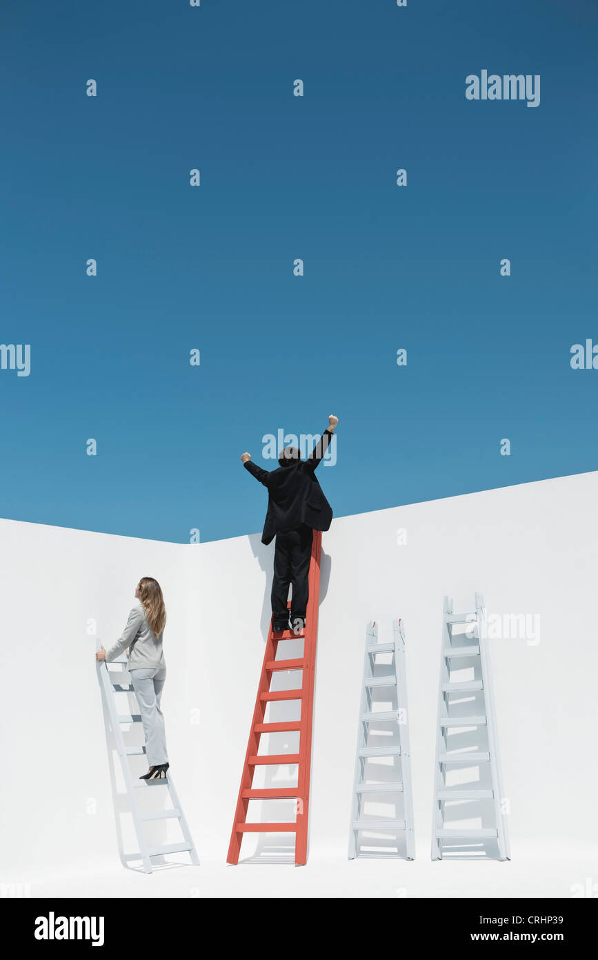 Businessman and businesswoman climbing ladders of success Stock Photo
