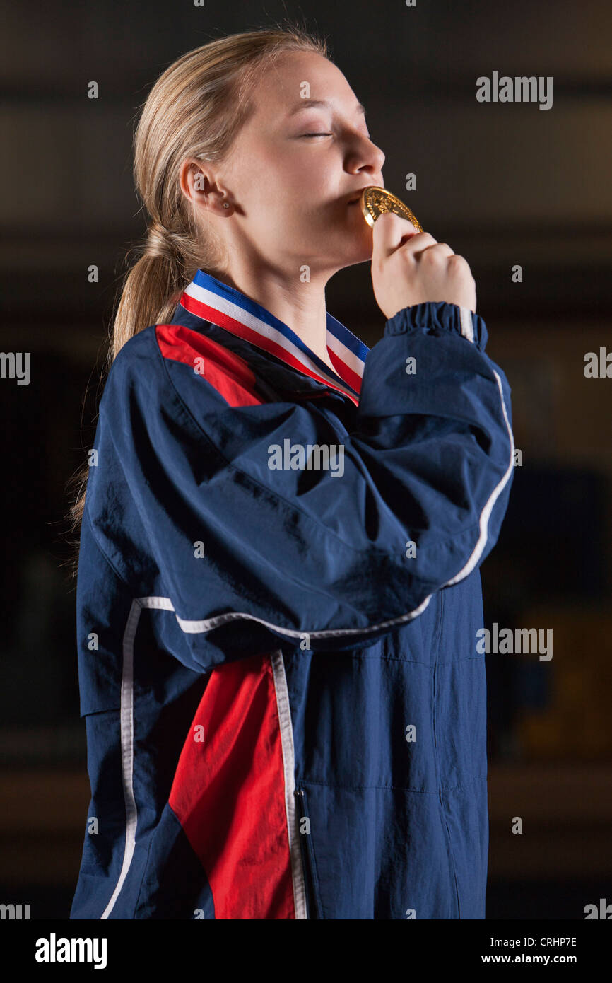 Female athlete kissing gold medal Stock Photo Alamy