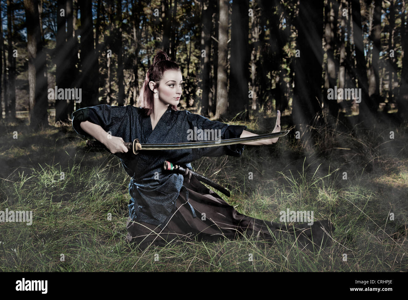 Female samurai warrior in an attacking stance Stock Photo