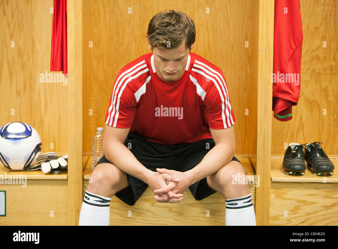 Soccer player sitting alone in locker room Stock Photo - Alamy