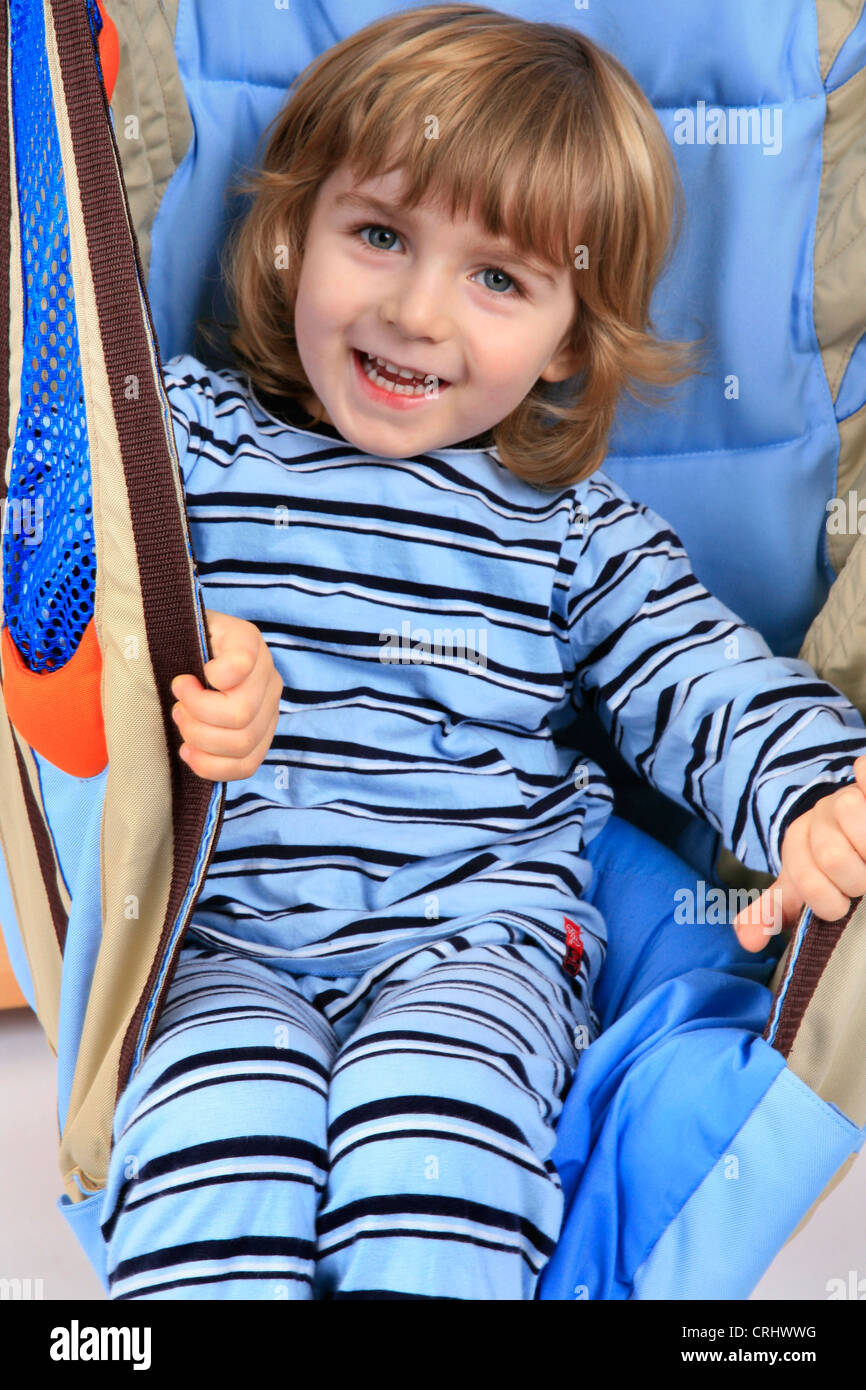 little boy in pyjama in a swing of a Billi-Bolli loft bed Stock Photo