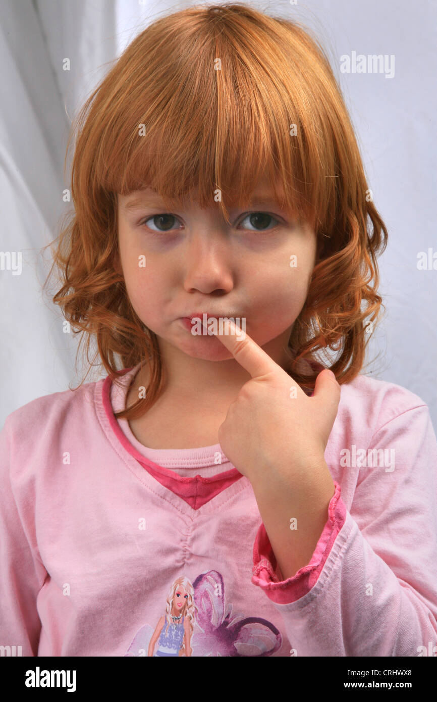 little redhaired girl in pyjama sulking doesn't want to go to bed Stock Photo