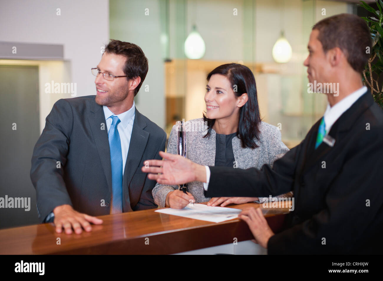 Business people checking into hotel Stock Photo Alamy