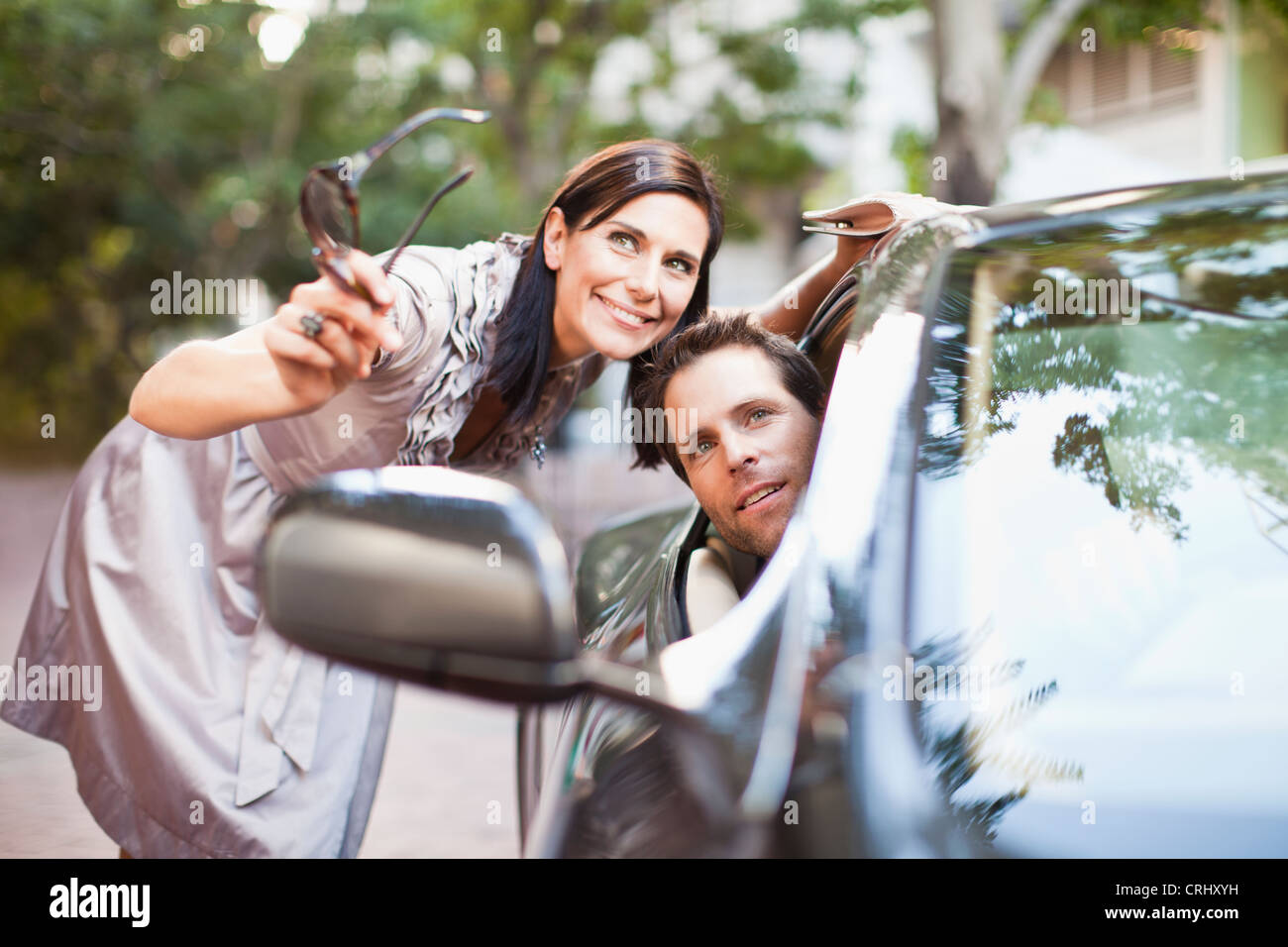 Woman giving directions to man in car Stock Photo - Alamy