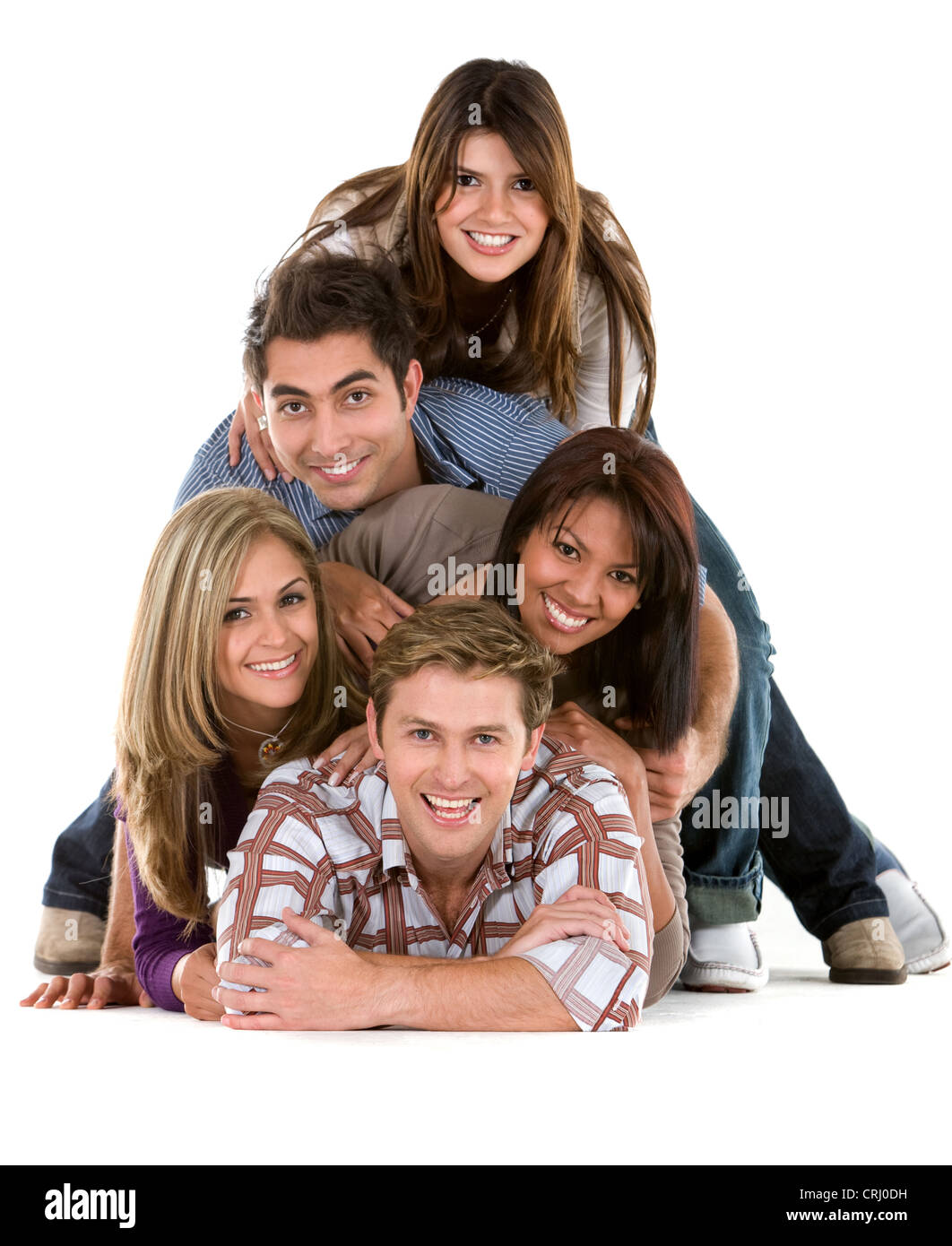 five happy young people lying on the floor one upon the other forming a pyramid Stock Photo