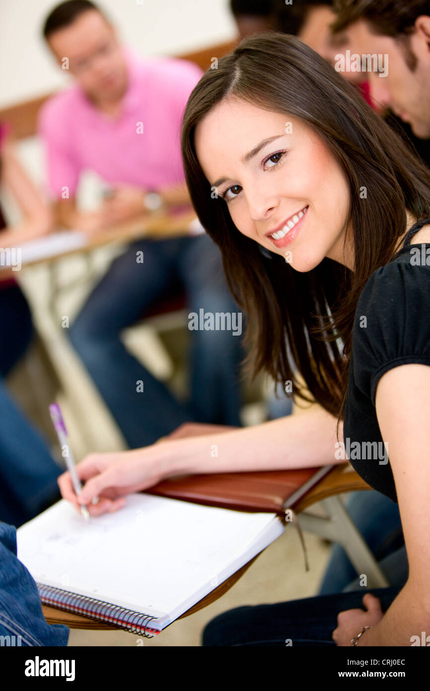 female university student making notes in a ring binder during seminar Stock Photo