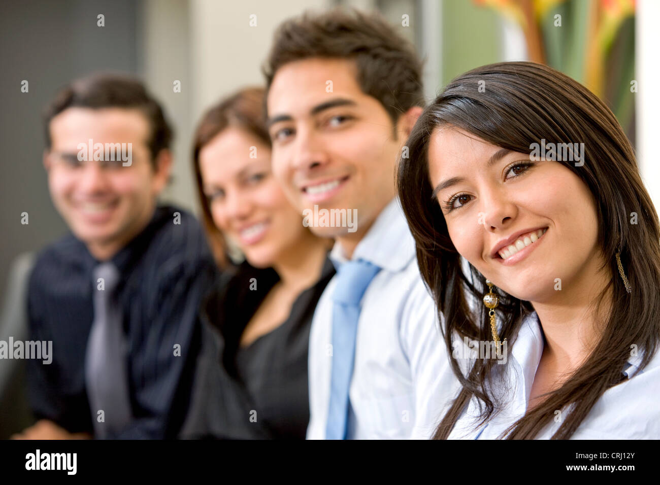four smiling well-goomed young people, woman in the foreground Stock Photo