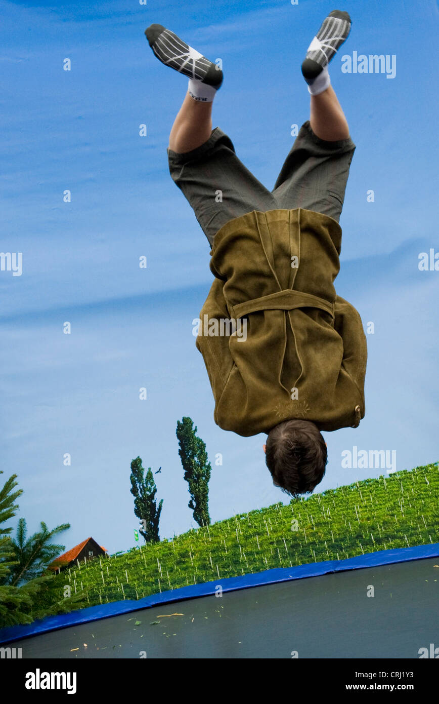 jumping Styrian person on trampoline, Austria, Styria Stock Photo