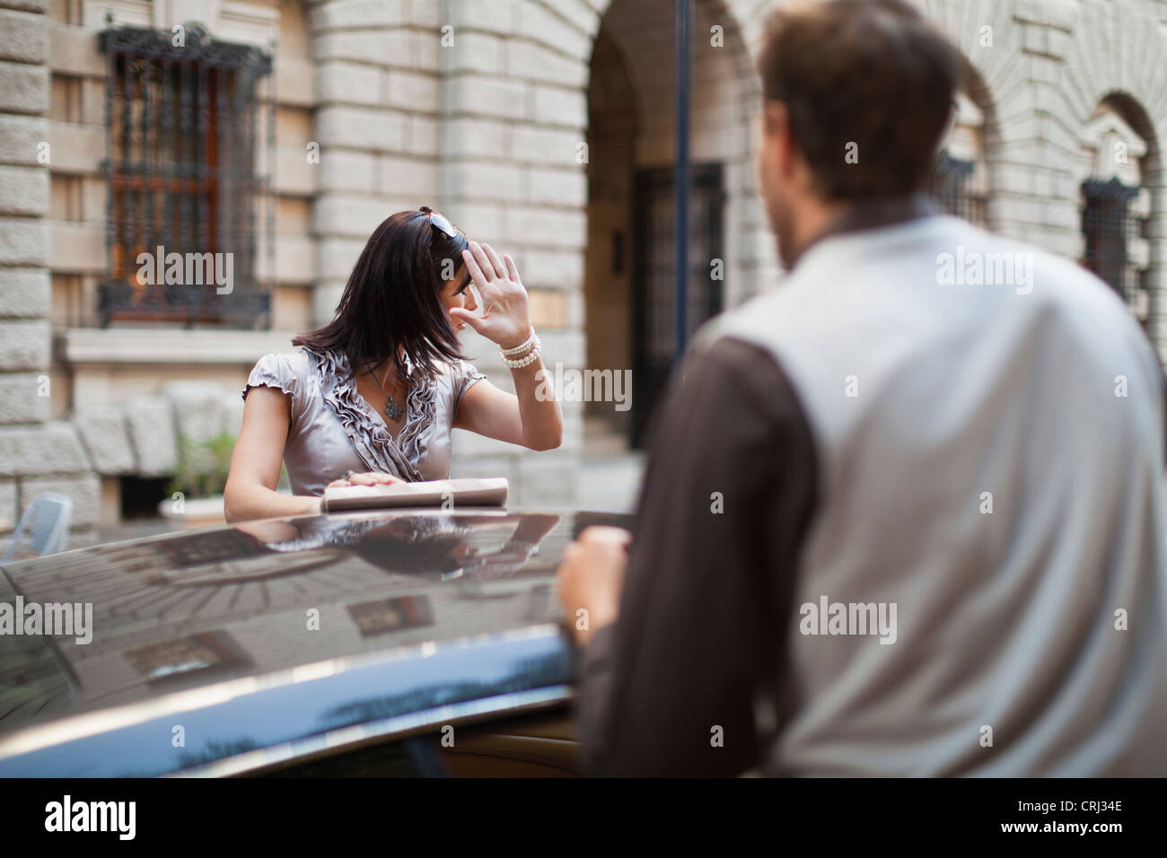 Couple arguing over sports car Stock Photo