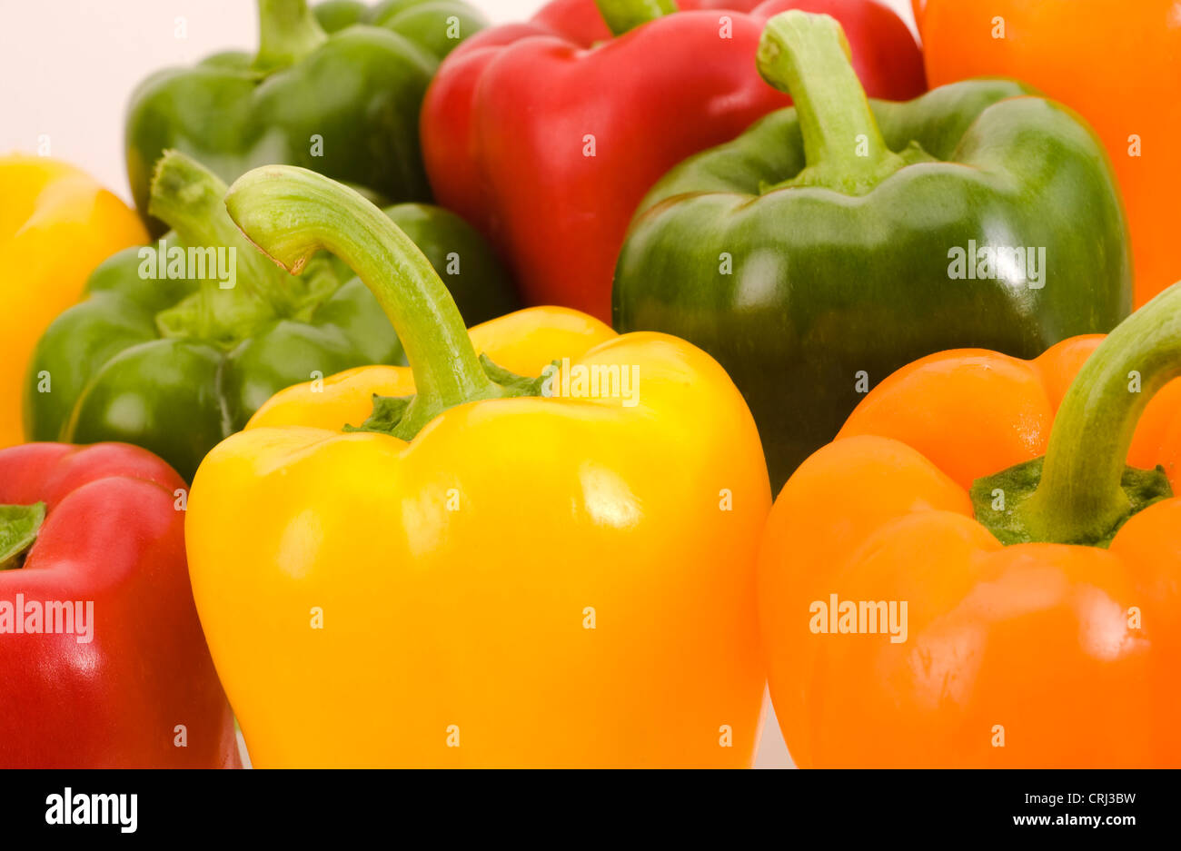 Peppers. Peppers contain vitamin C and vary in colour, due to their maturity. This colour varies through green to yellow to red. Stock Photo