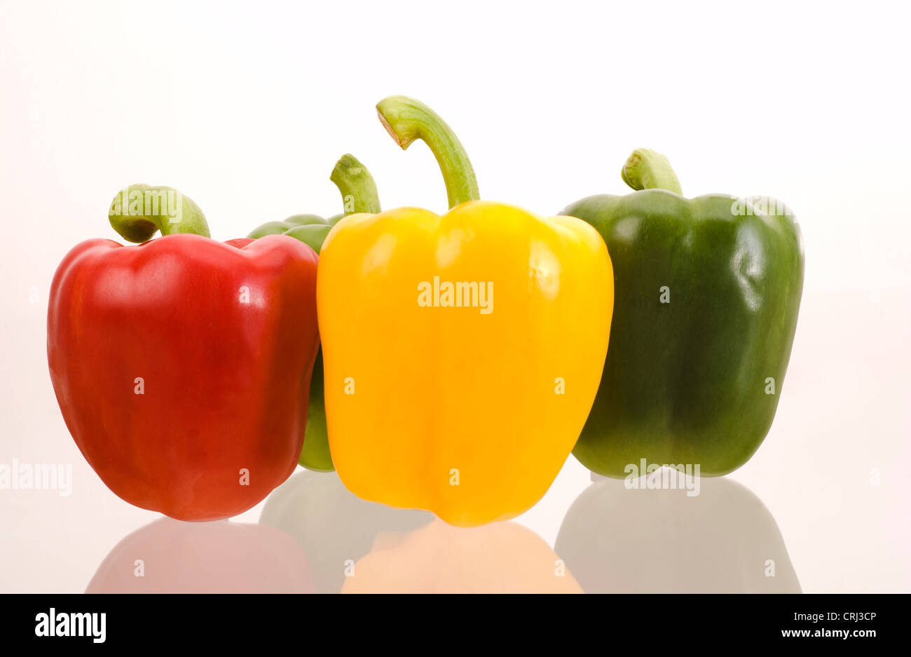 Peppers. Peppers contain vitamin C and vary in colour, due to their maturity. This colour varies through green to yellow to red. Stock Photo