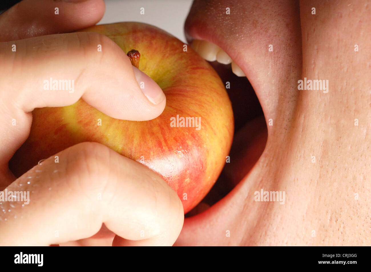 man biting into an apple Stock Photo - Alamy