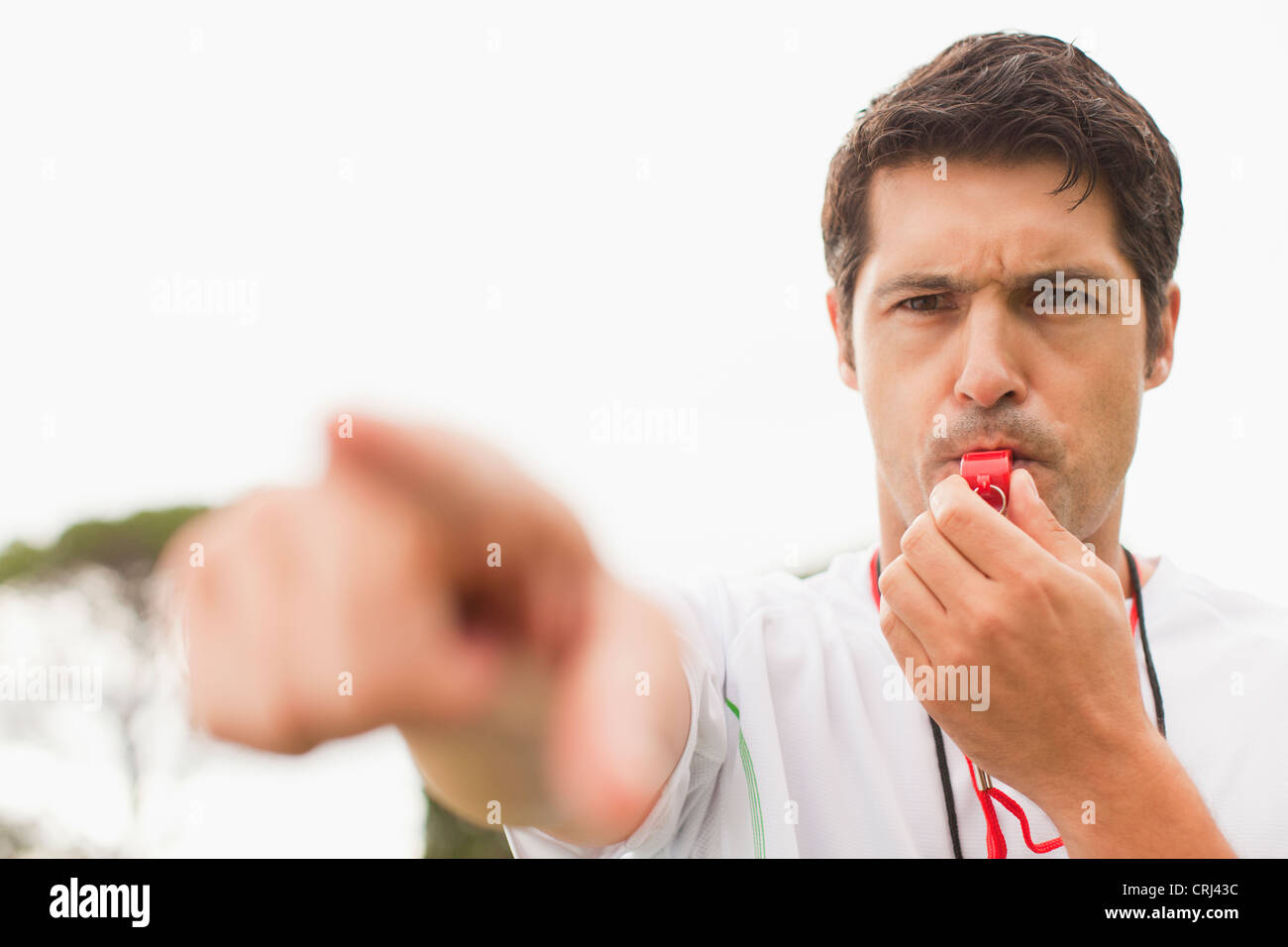Referee blowing whistle in game Stock Photo