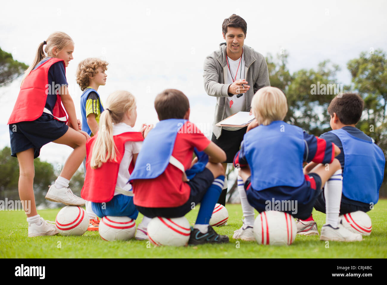 Coach talking to childrens soccer team Stock Photo