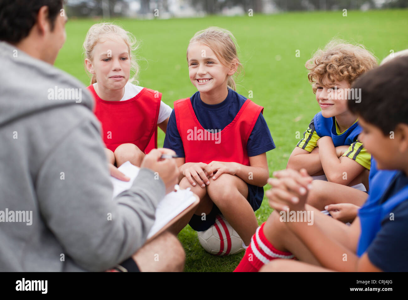 Coach talking to childrens soccer team Stock Photo
