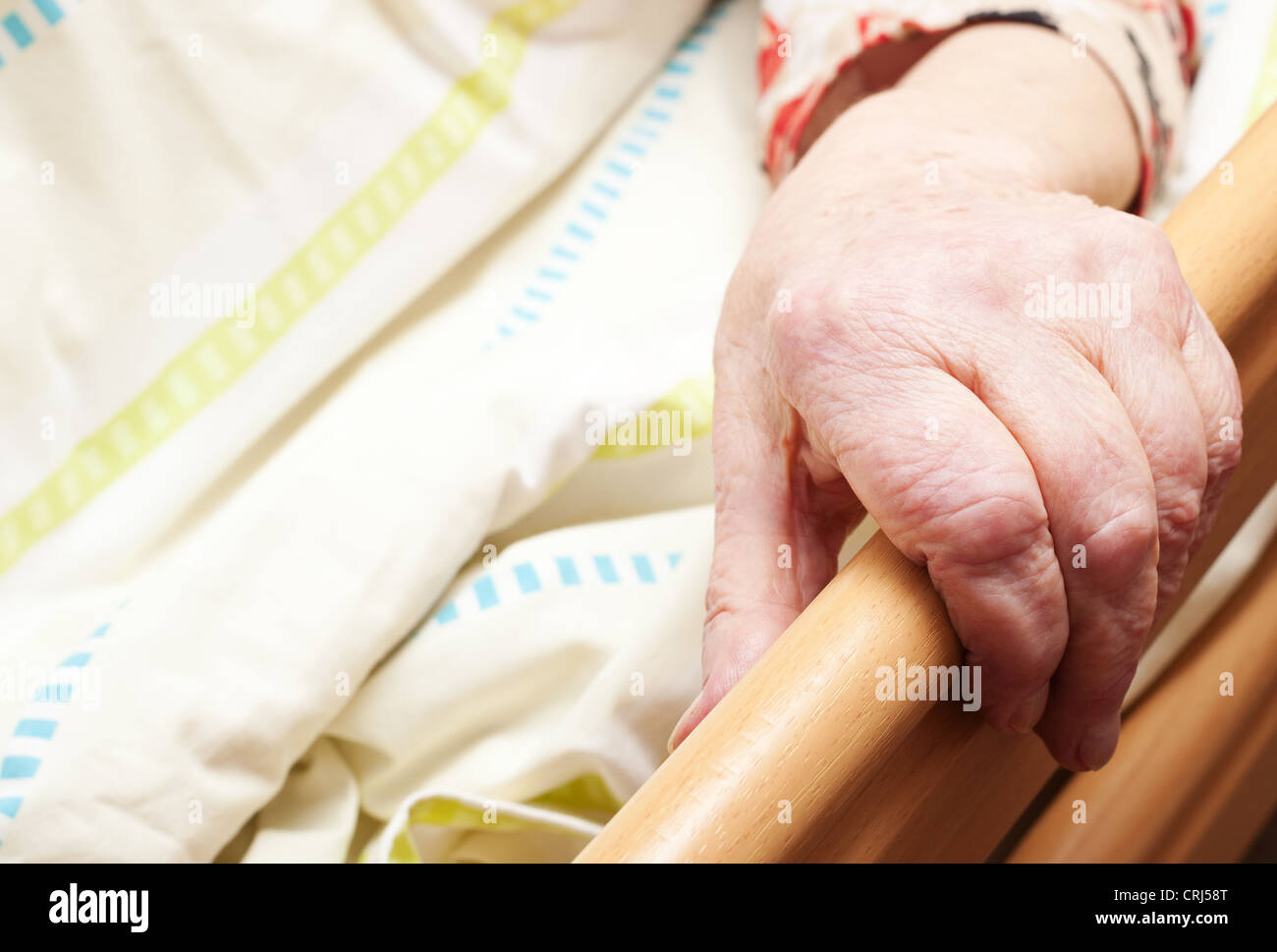 Care-dependent person lying in bed. Stock Photo
