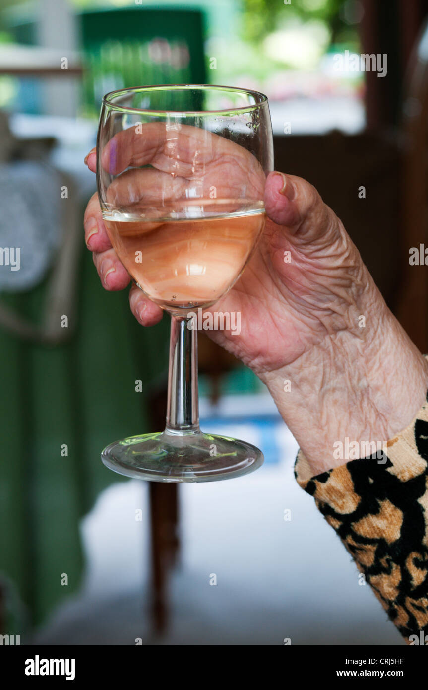 Old ladies hand with glass of wine hires stock photography and images