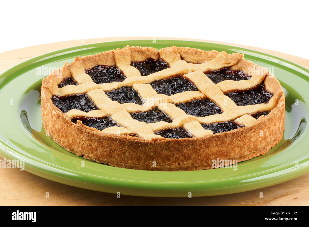 Homemade cherry jam tart on a green dish over a wooden background. With copy space. Stock Photo